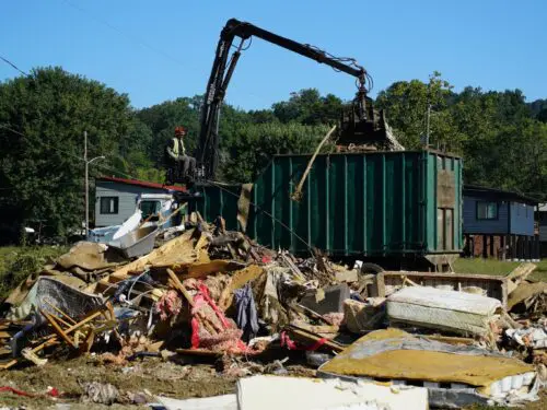 A claw operator scoops up debris from homes demolished following Hurricane Helene in Old Fort, North Carolina, on Thursday, Sept. 11, 2025