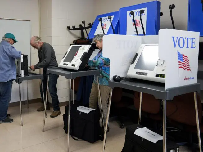 FILE - Poll workers set up ballot-marking machines at an early in-person voting site at Asheville-Buncombe Technical Community College, Wednesday, Oct. 16, 2024, in Marshall, North Carolina.