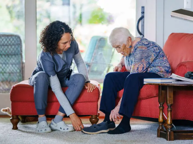 Caregiver helping elderly woman